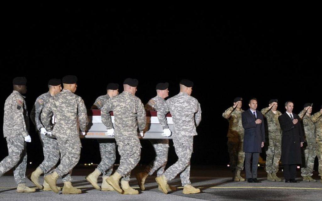 In this Monday, November 7, 2016 file photo, an Army carry team moves a transfer case containing the remains of Sgt. 1st Class Matthew C. Lewellen past Army Secretary Eric Fanning, fifth from right, Undersecretary of Defense for Intelligence Marcel Lettre, third from right, and Gen. Daniel B. Allyn, right, Army vice chief of staff, at Dover Air Force Base, Delaware.
