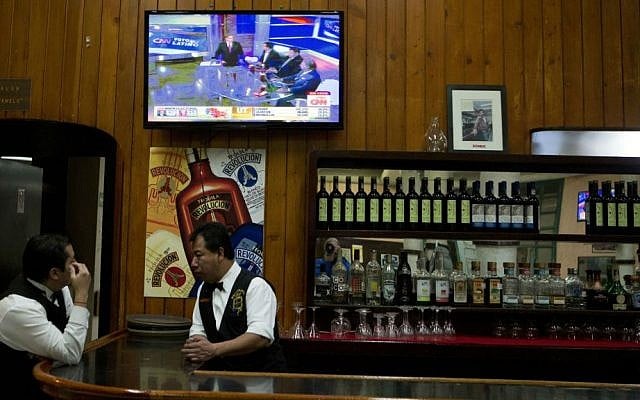 A waiter watches a local analysis of incoming US election results on a television in a traditional Mexican cantina in Mexico City, early Wednesday, Nov. 9, 2016. (AP Photo/Rebecca Blackwell)