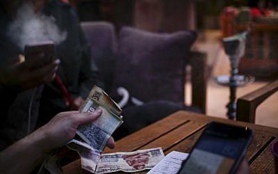 A man pays his bill as his friend smokes a waterpipe, or shisha, at a cafe in Cairo, Egypt, October 22, 2016. (AP Photo/Nariman El-Mofty) A man pays his bill as his friend smokes a waterpipe, or shisha, at a cafe in Cairo, Egypt, October 22, 2016. (AP Photo/Nariman El-Mofty)