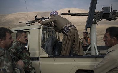 Taken on Tuesday, Nov. 8, 2016,  a Kurdish Peshmerga fighter looks at Islamic State militant positions during heavy fighting in Bashiqa, east of Mosul, Iraq. (AP Photo/Felipe Dana, File)