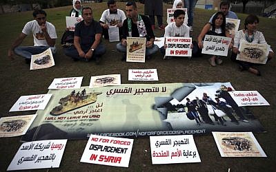 In this picture taken on Friday, Oct. 7, 2016, Syrian citizens attend a sit-in against the forced displacement in Syria, in front the United Nations headquarters, in downtown Beirut, Lebanon. (AP Photo/Hussein Malla)