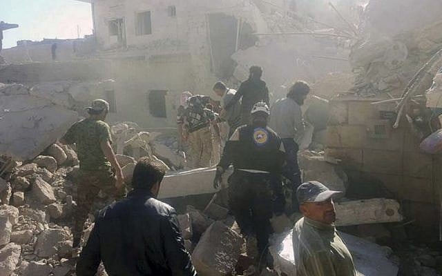 This photo provided by the Syrian Civil Defense White Helmets shows Civil Defense workers and Syrian citizens inspecting damaged buildings after airstrikes hit in Darat Izza town, in rural western Aleppo province, Syria, Saturday, Nov. 5, 2016.(Syrian Civil Defense White Helmets via AP) 