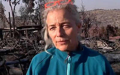Rama Ben Zvi walking amid the smoldering embers of her burned down restaurant, on Saturday, November 26 2016. (Screen capture Channel 2)