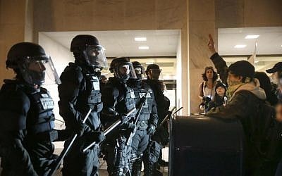Police stand in front of people who marched through downtown Portland, Ore., to protest of the election of president-elect, Donald Trump, Friday, Nov. 11, 2016. (Stephanie Yao Long/The Oregonian via AP)