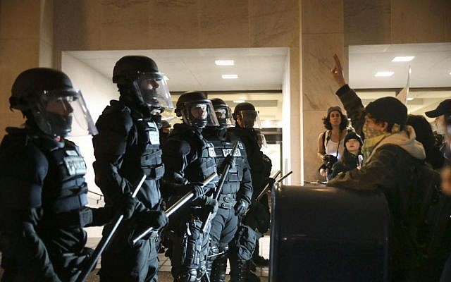 Police stand in front of people who marched through downtown Portland, Ore., to protest of the election of president-elect, Donald Trump, Friday, Nov. 11, 2016. (Stephanie Yao Long/The Oregonian via AP) Police stand in front of people who marched through downtown Portland, Ore., to protest of the election of president-elect, Donald Trump, Friday, Nov. 11, 2016. (Stephanie Yao Long/The Oregonian via AP)