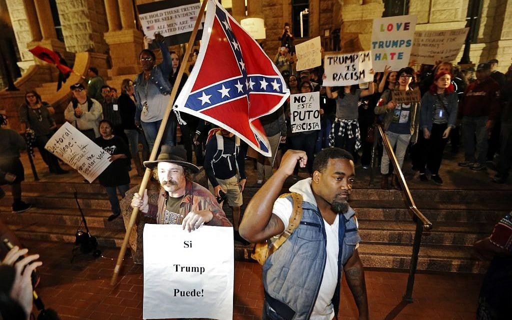 A Trump supporter with a flag, left, counter protests as a small group outside the courthouse protests in opposition of President-elect Donald Trump, Friday, November 11, 2016, in Fort Worth, Texas. (Brandon Wade/Star-Telegram via AP) A Trump supporter with a flag, left, counter protests as a small group outside the courthouse protests in opposition of President-elect Donald Trump, Friday, November 11, 2016, in Fort Worth, Texas. (Brandon Wade/Star-Telegram via AP)