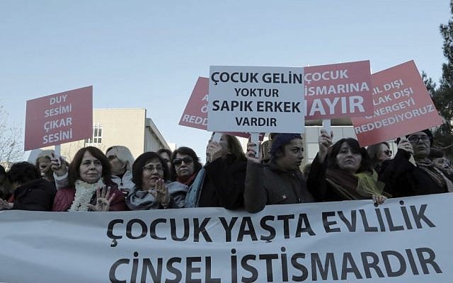 Women hold placards denouncing child marriages as thousands of members of Turkey's main opposition Republican People's Party march to the parliament in Ankara, Turkey, Tuesday, Nov. 22, 2016. The banner reads: " Child marriage is sexual exploitation." (AP Photo/Burhan Ozbilici)