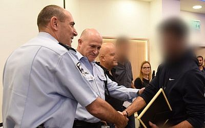 Police top brass present an award to the officer who as an undercover agent helped to identify more than 37 people arrested on November 21, 2016 in a countrywide swoop on suspected drug and weapons dealers. (Israel Police spokesman‘s office) Police top brass present an award to the officer who as an undercover agent helped to identify more than 37 people arrested on November 21, 2016 in a countrywide swoop on suspected drug and weapons dealers. (Israel Police spokesman‘s office)