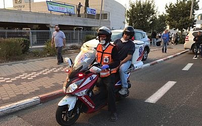 Education Minister Naftali Bennett rides pillion on a United Hatzalah ambucycle to assess the situation in Haifa on November 24, 2016, as fires rage across the city. (United Hatzalah)