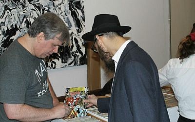 A man examining a comic book for sale at the inaugural Jewish Comic Con, held at Congregation Kol Israel, a Brooklyn synagogue, November 13, 2016. (Ben Sales/JTA)