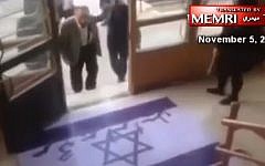 An Iranian professor avoids stepping on an Israeli flag painted onto the ground at a university in northeastern Iran, in footage released November 5, 2016. (MEMRI/screenshot)