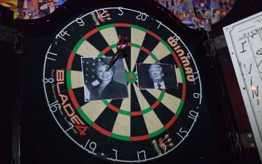 An image of Hillary Clinton is speared by a dart on a dartboard at Mike's Place bar in Jerusalem early November 9, 2016. Donald Trump supporters were watching the results of the US presidential race at the watering hole. (Melanie Lidman/Times of Israel) An image of Hillary Clinton is speared by a dart on a dartboard at Mike's Place bar in Jerusalem early November 9, 2016. Donald Trump supporters were watching the results of the US presidential race at the watering hole. (Melanie Lidman/Times of Israel)
