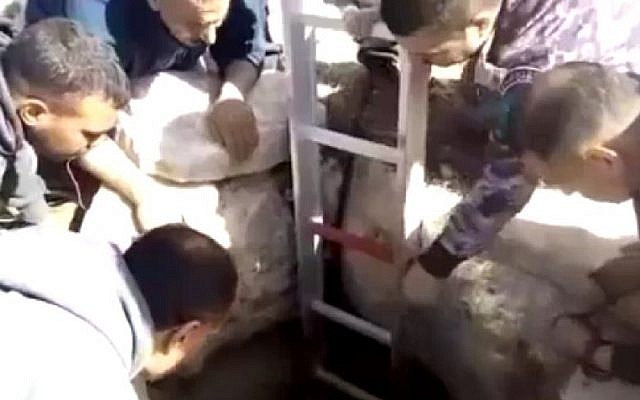 Palestinian Civil Defense members rescue an Israeli settler who had been stuck in a pit for six days, November 26, 2016. (Screenshot/Channel 10)