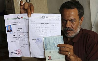Syrian refugee, Majed al-Attar, poses while showing his expired Syrian passport and Palestinian identification documents at his family's rented house in Rafah, Gaza, October 31, 2016 (AP Photo/Adel Hana)
