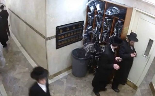 Screen capture of security camera footage showing a tefillin set falling from a cubby into a garbage bin at a Satmar Hasidic synagogue in Brooklyn, New York. (YouTube screen capture/Yeshiva World News) Screen capture of security camera footage showing a tefillin set falling from a cubby into a garbage bin at a Satmar Hasidic synagogue in Brooklyn, New York. (YouTube screen capture/Yeshiva World News)