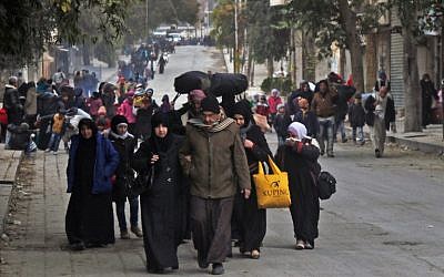 Syrian residents of eastern rebel-held parts of Aleppo walk through the Kadi Askar district as they leave their homes for a safer place in a distinct rebel-controlled area on November 30, 2016, during a Syrian army offensive on the eastern sectors of the divided city. (AFP PHOTO / THAER MOHAMMED)