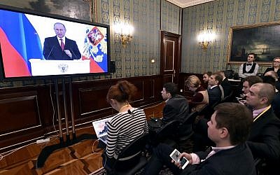 Journalists watch a live broadcast of Russian President Vladimir Putin's Federal Assembly address at a press room at the Kremlin in Moscow on December 1, 2016. (AFP /Natalia KOLESNIKOVA)