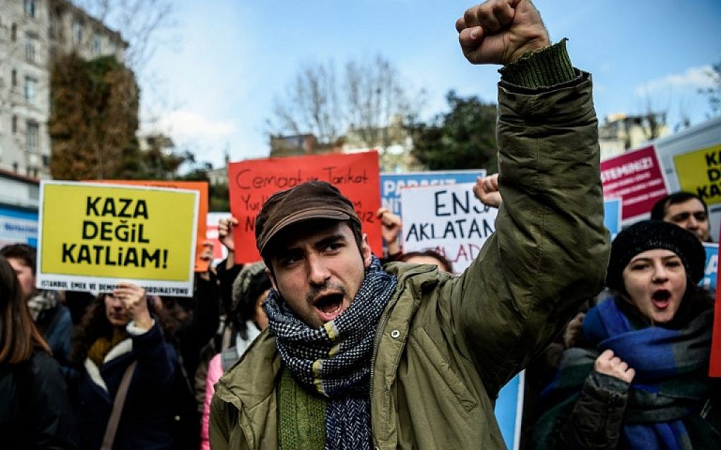 Turkish protesters shout slogans and hold a placard reading "This is not an accident, but a massacre" during a demonstration in Istanbul on December 1, 2016 following a deadly fire in the southern region of Adana. (AFP/ OZAN KOSE)