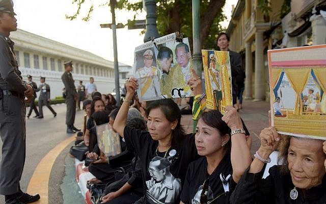 Women hold images of Thai Crown Prince Maha Vajiralongkorn with his father, the late Thai King Bhumibol Adulyadej, outside the Grand Palace in Bangkok on December 1, 2016. (AFP PHOTO/TANG CHHIN SOTHY)