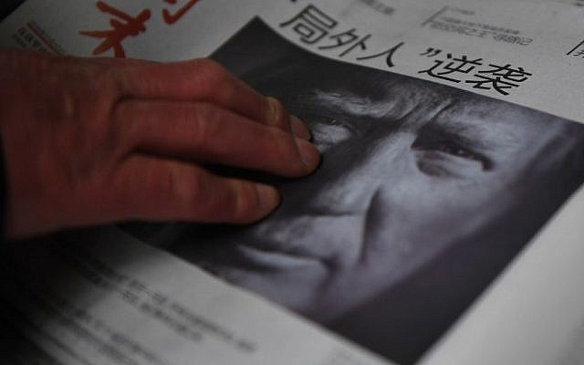This file photo taken on November 10, 2016 shows a man buying a newspaper featuring a photo of US President-elect Donald Trump, the day after the US election, at a news stand in Beijing on November 10, 2016. The headline reads 'Outsider strikes back.' (AFP/Greg Baker) This file photo taken on November 10, 2016 shows a man buying a newspaper featuring a photo of US President-elect Donald Trump, the day after the US election, at a news stand in Beijing on November 10, 2016. The headline reads 'Outsider strikes back.' (AFP/Greg Baker)