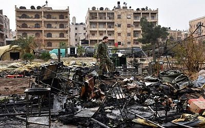 A Russian soldier inspects the damage at a field hospital that was reportedly destroyed by rebel shelling on December 5, 2016 in the Furqan neighborhood of the government-held side of west Aleppo. (AFP PHOTO / GEORGE OURFALIAN)