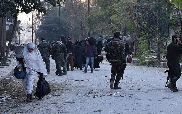 Syrian residents fleeing the violence in the eastern rebel-held parts of Aleppo evacuate from their neighbourhoods through the Bab al-Hadid district after it was seized by the government forces, on December 7, 2016. (AFP/GEORGE OURFALIAN)