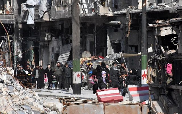 Syrian residents of the newly retaken eastern neighborhoods of Aleppo walk through the Bab al-Hadid district as they return home under supervision of the Syrian pro-government forces on December 8, 2016. (AFP PHOTO/GEORGE OURFALIAN)