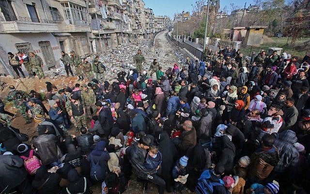 Syrian residents fleeing the violence gather at a checkpoint, manned by pro-government forces, in the Maysaloun neighborhood of the northern embattled Syrian city of Aleppo on December 8, 2016.
(AFP PHOTO / Youssef KARWASHAN) Syrian residents fleeing the violence gather at a checkpoint, manned by pro-government forces, in the Maysaloun neighborhood of the northern embattled Syrian city of Aleppo on December 8, 2016.
(AFP PHOTO / Youssef KARWASHAN)