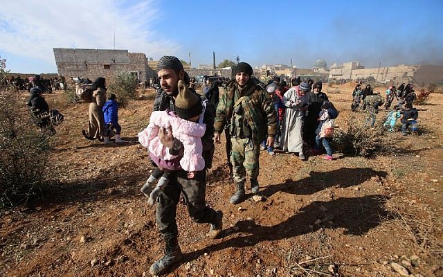 Syrian residents fleeing the violence gather at a checkpoint, manned by pro-government forces, in the village of Aziza on the southwestern outskirts of the northern Syrian city of Aleppo on December 8, 2016.
(AFP PHOTO / Youssef KARWASHAN)