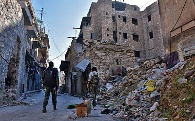 Syrian pro-government forces walks past rubble in old Aleppo's Jdeideh neighborhood on December 9, 2016. (AFP/George Ourfalian)