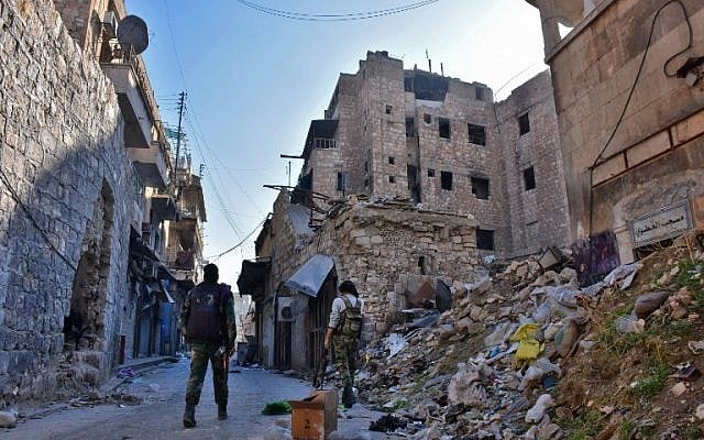 Syrian pro-government forces walks past rubble in old Aleppo's Jdeideh neighbourhood on December 9, 2016. ( AFP PHOTO / George OURFALIAN)