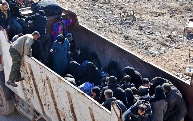 Syrian residents fleeing the violence, are seen standing in the back of a truck as they arrive at a checkpoint manned by pro-government forces, in the village of Aziza on the southwestern outskirts of the northern Syrian city of Aleppo on December 9, 2016. (AFP PHOTO / George OURFALIAN)