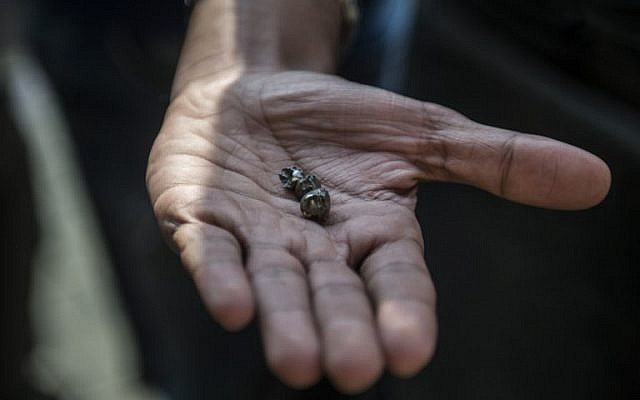 An Egyptian man shows small pieces of metal outside the Saint Peter and Saint Paul Coptic Orthodox Church after it was targeted by a bomb explosion on December 11, 2016, in Cairo's Abbasiya neighborhood. (AFP PHOTO / KHALED DESOUKI)