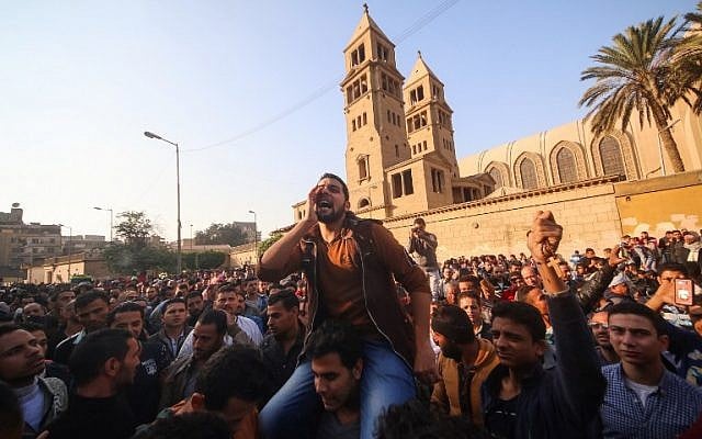Egyptians shout slogans as they gather outside the the Saint Peter and Saint Paul Coptic Orthodox Church in Cairo's Abbasiya neighborhood after it was targeted by a bomb explosion on December 11, 2016, (AFP PHOTO / MOHAMED METEAB)