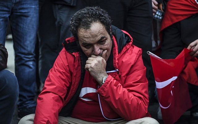 A Turkish man cries as people gather to pay their respects outside the Vodafone Arena soccer stadium in Istanbul on December 11, 2016, a day after twin bombings near the home stadium of Besiktas football club. (AFP PHOTO / BULENT KILIC)