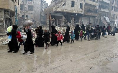 Syrian residents, fleeing violence in the restive Bustan al-Qasr neighbourhood, arrive in Aleppo's Fardos neighborhood on December 13, 2016, after regime troops retook the area from rebel fighters. (AFP/STRINGER)