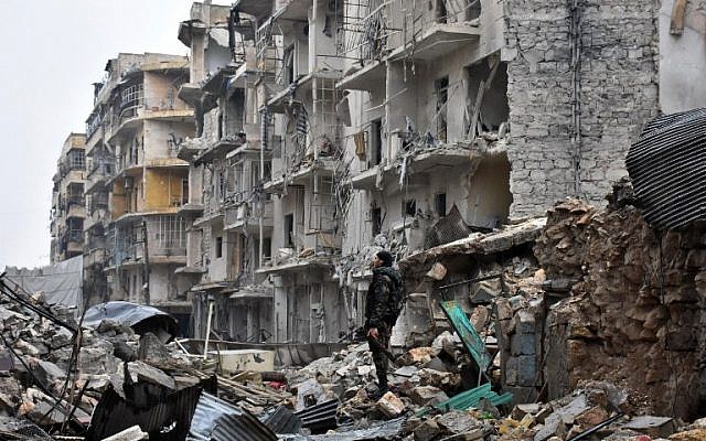 A member of the Syrian government forces stands in a severely damaged street in Aleppo's newly captured Al-Kalasseh neighborhood in the eastern part of the war torn city on December 13, 2016. (AFP PHOTO / George OURFALIAN) A member of the Syrian government forces stands in a severely damaged street in Aleppo's newly captured Al-Kalasseh neighborhood in the eastern part of the war torn city on December 13, 2016. (AFP PHOTO / George OURFALIAN)
