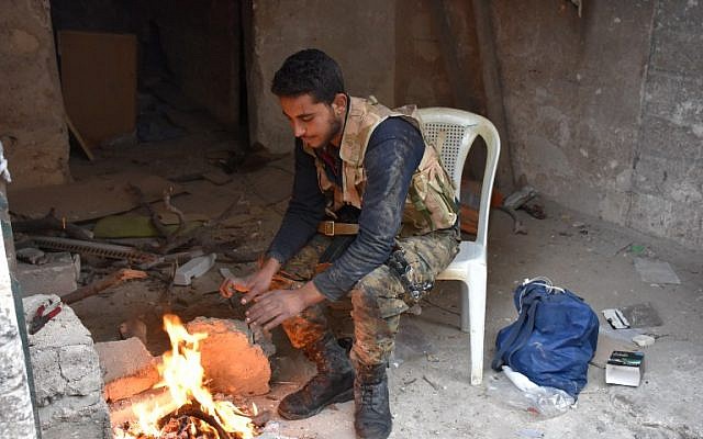 A member of the Syrian government forces warms his hands on a fire in Aleppo's newly captured Al-Kalasseh neighborhood in the eastern part of the war torn city on December 13, 2016. (AFP PHOTO/George OURFALIAN) A member of the Syrian government forces warms his hands on a fire in Aleppo's newly captured Al-Kalasseh neighborhood in the eastern part of the war torn city on December 13, 2016. (AFP PHOTO/George OURFALIAN)