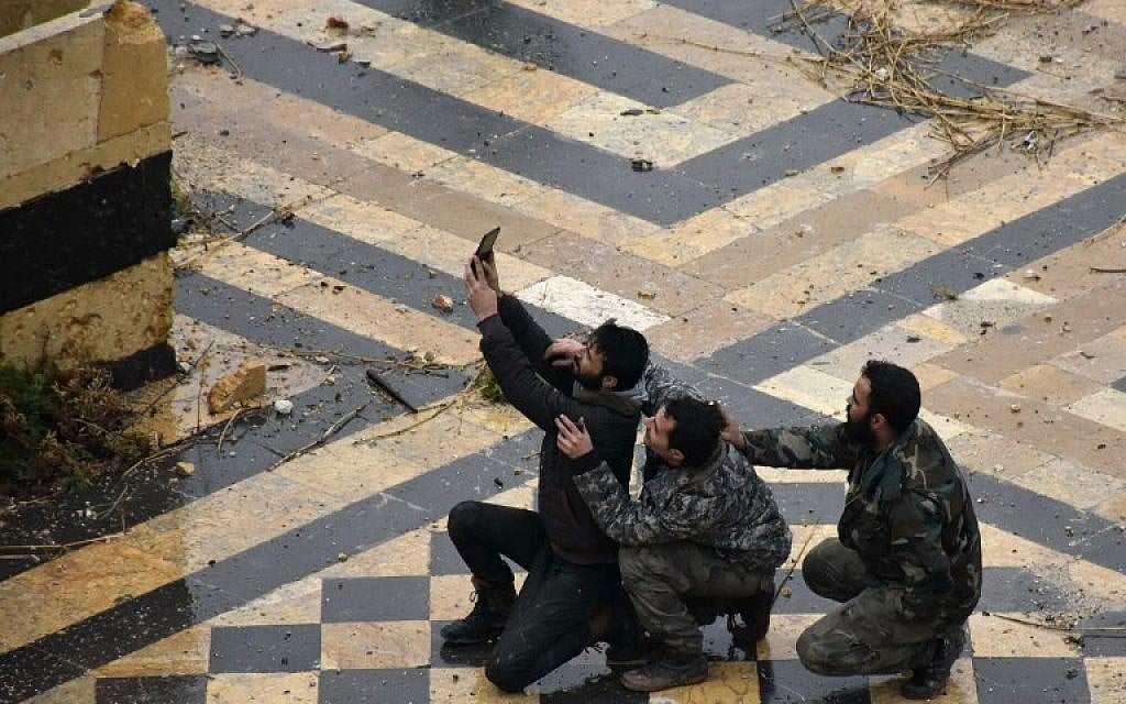 Syrian pro-government forces take a selfie in the courtyard of the ancient Umayyad mosque in the old city of Aleppo on December 13, 2016. (AFP PHOTO/George OURFALIAN)