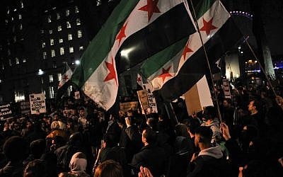 Protesters wave flags during a demonstration in solidarity with the inhabitants of the embattled Syrian city of Aleppo, outside the entrance to Downing Street, in central London on December 13, 2016.(AFP PHOTO / Daniel SORABJI