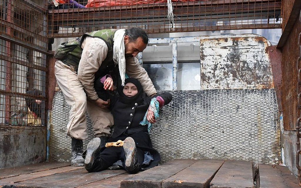 A wounded Syrian woman from the al-Sukari neighborhood is helped onto the back of a truck as she flees during the ongoing government operation to retake remaining rebel-held areas in Aleppo on December 14, 2016. (AFP PHOTO/George OURFALIAN)