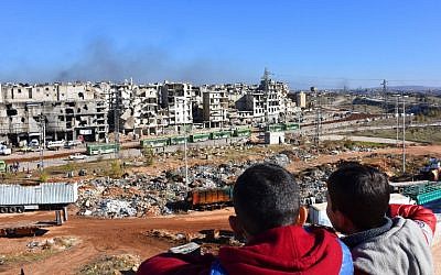 Syrian children watch on as buses depart during an evacuation operation of rebel fighters and their families from rebel-held neighborhoods in the embattled city of Aleppo on December 15, 2016 (AFP PHOTO / George OURFALIAN)