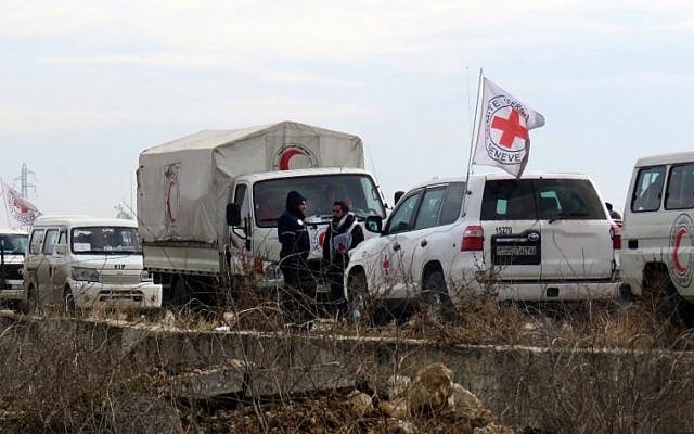 Staff from the International Red Cross and from the Syrian Red Crescent wait as civilians and fighters are evacuated from Aleppo towards rebel-held territory on December 16, 2016. (AFP PHOTO/STRINGER)