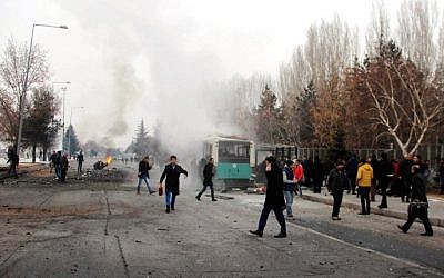 This picture obtained from the Ihlas News Agency shows a police officer and people walking next to the wreck of public bus following an explosion on December 17, 2016 in Kayseri, central Turkey. (AFP PHOTO / IHLAS NEWS AGENCY / IHLAS NEWS AGENCY)