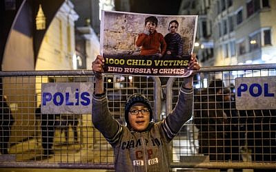 A Syrian boy living in Turkey holds a sign during a protest against Russia, Syrian president Bashar Assad's regime ally, in front of the Russian Embassy along Istiklal Avenue in Istanbul on December 17, 2016. (AFP PHOTO/OZAN KOSE)