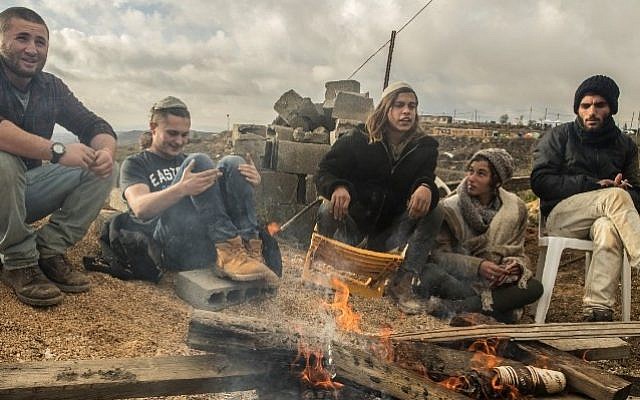 Young Israeli settlers gather around a fire in the settlement outpost of Amona, which was established in 1997 and built on private Palestinian land, in the West Bank on December 18, 2016. (AFP PHOTO / JACK GUEZ) Young Israeli settlers gather around a fire in the settlement outpost of Amona, which was established in 1997 and built on private Palestinian land, in the West Bank on December 18, 2016. (AFP PHOTO / JACK GUEZ)