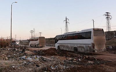 Buses drive through the Syrian government-controlled crossing of Ramoussa, on the southern outskirts of Aleppo, on December 18, 2016, during an evacuation operation of rebel fighters and civilians from rebel-held areas. (AFP PHOTO / George OURFALIAN)