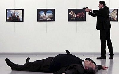 Andrei Karlov (bottom), the Russian ambassador to Ankara, lying on the floor, after being shot by Mevlut Mert Altintas (R), during an attack at a public event in Ankara, December 19, 2016. (AFP/Hurriyet/Hasim KILIC/Turkey Out)