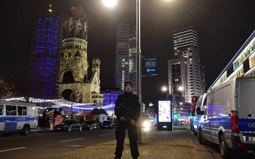 A police man stands at the site where a truck speeded into a Christmas market in Berlin, on December 19, 2016 killing nine persons and injuring at least 50 people. (AFP PHOTO / John MACDOUGALL)