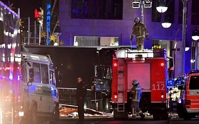 Police working next to the truck, center, that crashed into a Christmas market at Gedächniskirche church in Berlin, on December 19, 2016 killing at least twelve people and injuring at least 48. (AFP Photo/John MacDougall)
